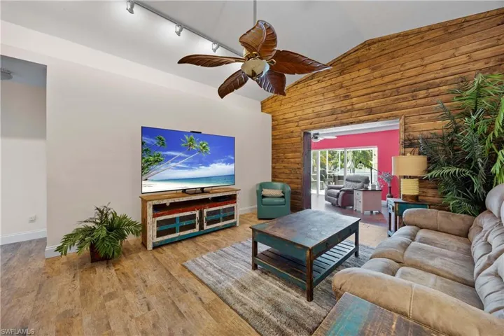 Living room with wood feature wall that leads out to an extra den/sunroom
