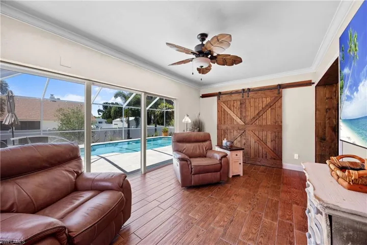 Extra den or living space that leads out to the pool and lanai area with lots of windows and natural light and barn door