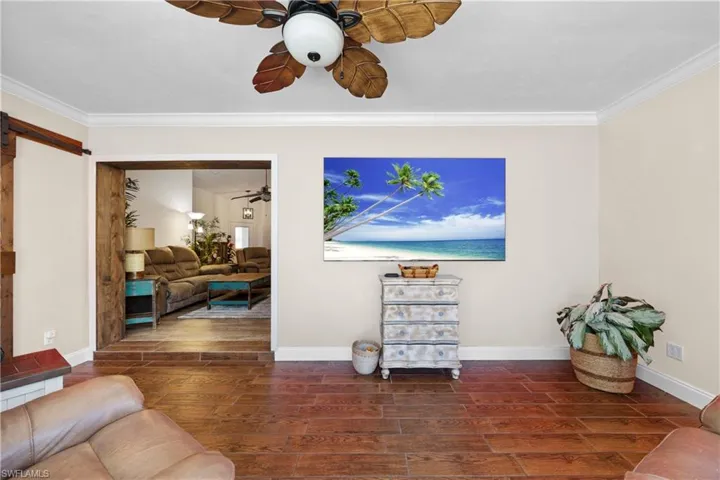 Extra den or living space that leads out to the pool and lanai area with lots of windows and natural light and barn door