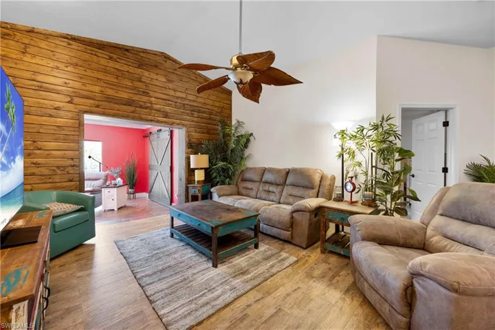 Living room with wood feature wall that leads out to your sunroom/den area