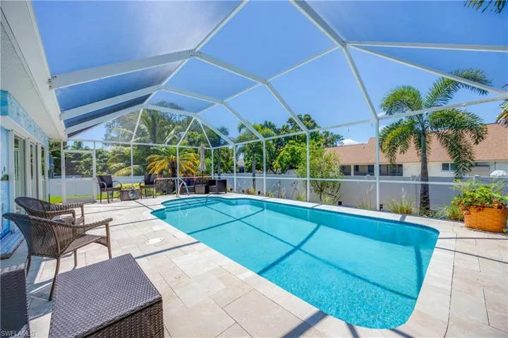 View of pool with lanai enclosure and a patio area