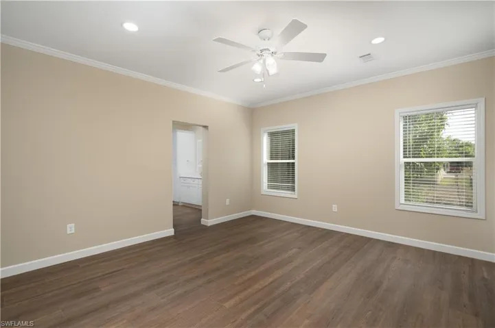 Unfurnished room featuring a ceiling fan, recessed lighting, dark wood-type flooring, plenty of natural light, and crown molding