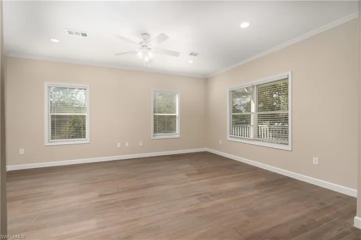 Spare room with crown molding, ceiling fan, dark wood-type flooring, and recessed lighting