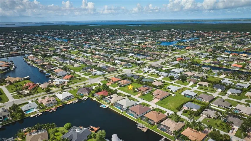 Aerial view of property's location with nearby suburban area and a nearby body of water