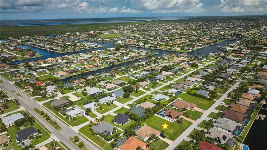 Aerial view of property's location featuring a large body of water and nearby suburban area