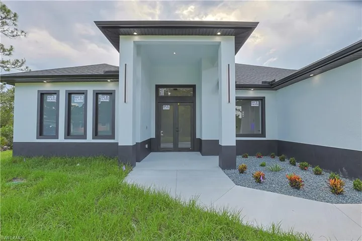 Entrance to property featuring stucco siding, french doors, and roof with shingles