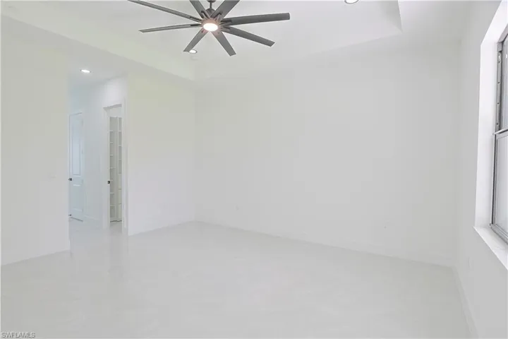 Spare room with recessed lighting, a ceiling fan, and a tray ceiling