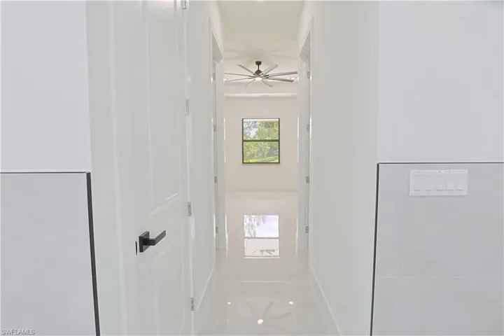 Hall with baseboards and light tile patterned floors