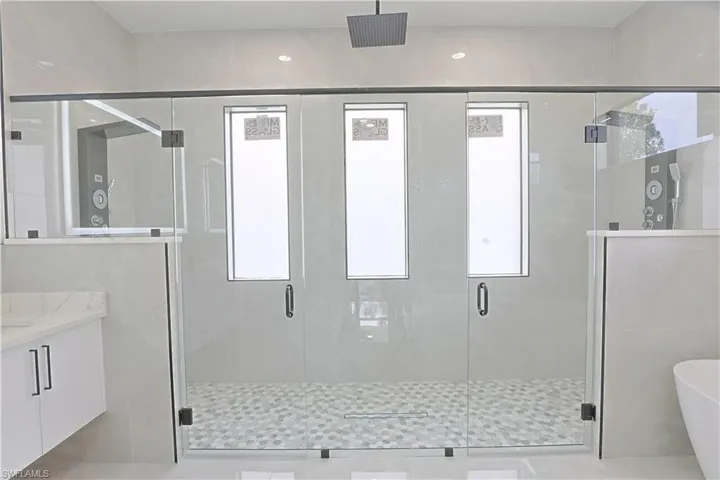 Full bath with a soaking tub, vanity, and a shower stall