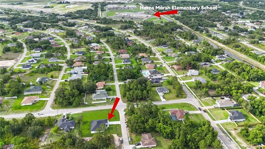 Aerial view of property and surrounding area featuring nearby suburban area