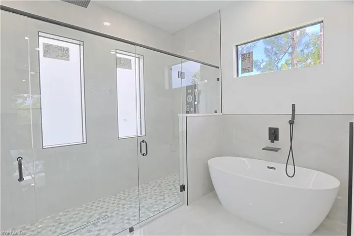 Full bath featuring a soaking tub and a stall shower