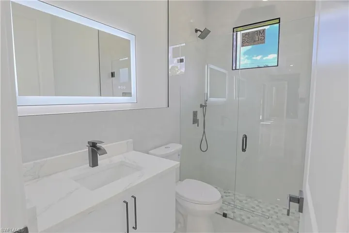 Full bath featuring a shower stall and vanity