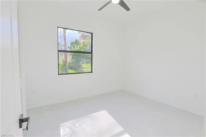 Unfurnished room with ceiling fan and baseboards
