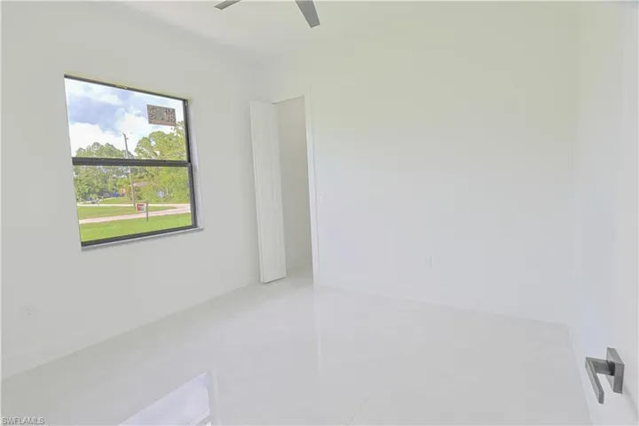 Empty room featuring a ceiling fan and light tile patterned floors