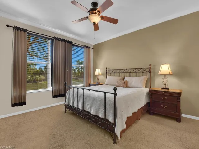 Bedroom with a ceiling fan and carpeting