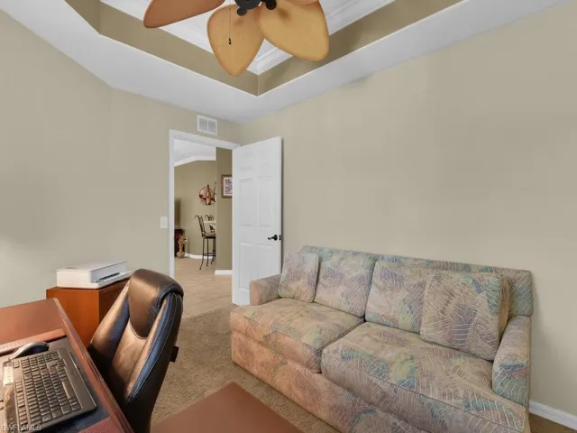 Office space with raised tray ceiling and carpet