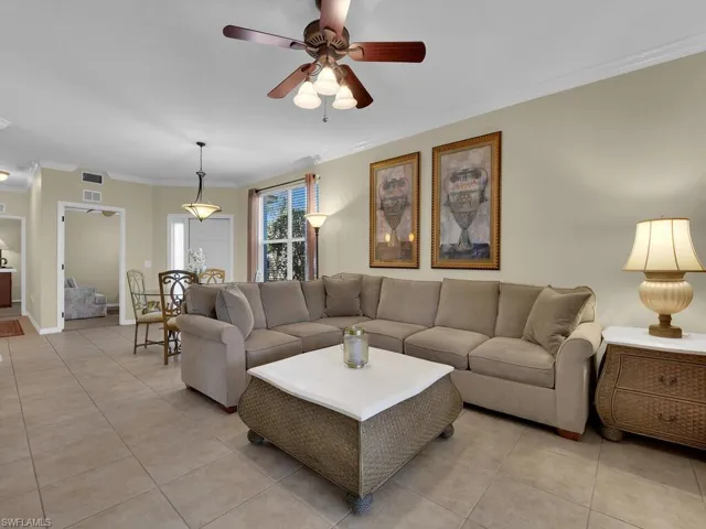 Living room featuring ornamental molding, a ceiling fan, and tile flooring