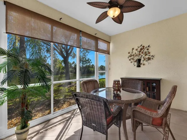 Sunroom / solarium featuring stucco wall, water view, and tile flooring