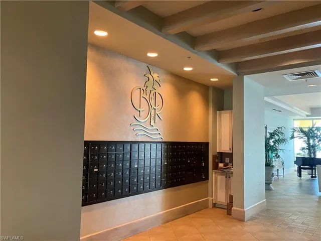 Mailroom area featuring recessed lighting, a decorative wall emblem, and an array of individual mailboxes.