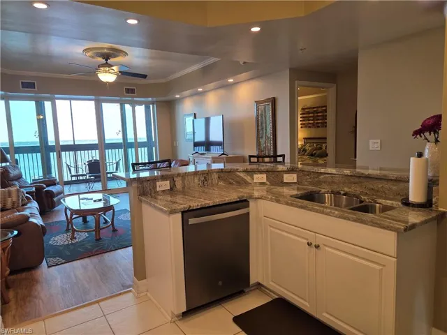 Kitchen featuring granite countertops, undermount double-basin sink, and white cabinetry