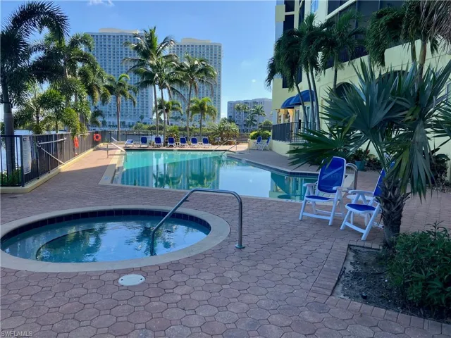 Outdoor swimming pool and hot tub surrounded by paver patio