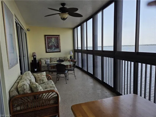 Enclosed balcony featuring floor-to-ceiling windows, a ceiling fan, and light-toned flooring