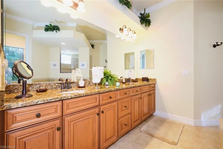 Bathroom with tile patterned flooring, vanity, and crown molding