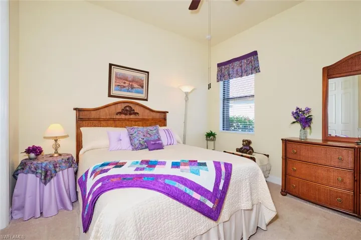 Bedroom with ceiling fan and light carpet