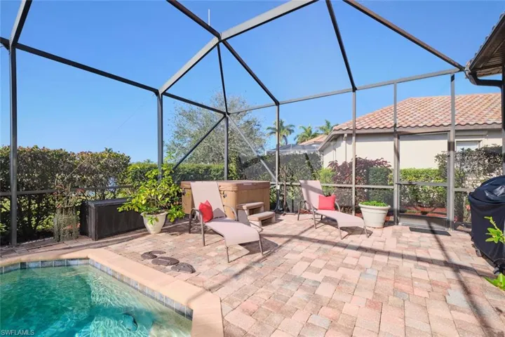 View of patio featuring a hot tub and a lanai