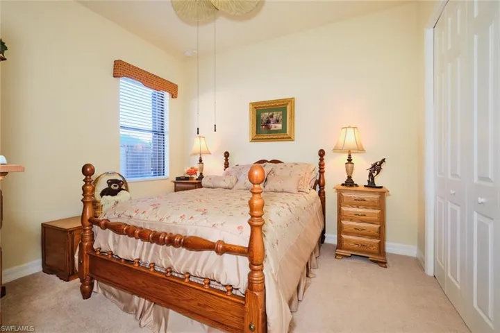 Carpeted bedroom featuring ceiling fan and a closet