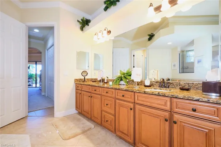 Bathroom featuring tile patterned flooring, vanity, and ornamental molding
