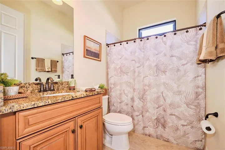 Bathroom featuring toilet, vanity, and tile patterned floors