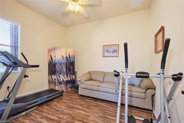 Workout area with hardwood / wood-style flooring and ceiling fan