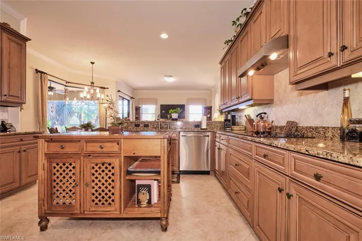 Kitchen with black electric cooktop, stainless steel dishwasher, crown molding, and range hood