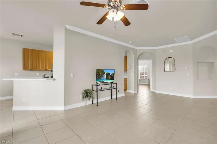 Living room featuring ceiling fan and crown molding