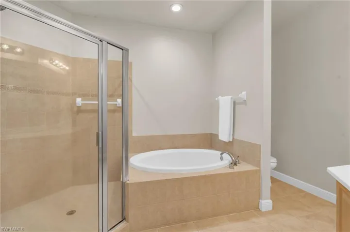 Full bathroom featuring shower with separate bathtub, and vanity