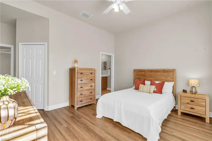 Bedroom featuring wood-style flooring, ceiling fan, and ensuite bathroom