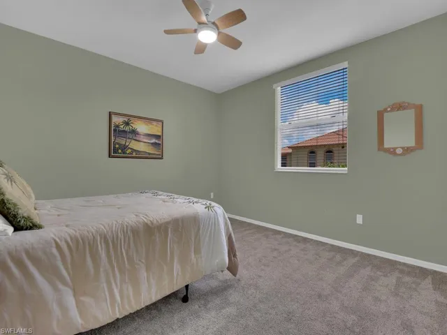 Room featuring a ceiling fan with integrated lighting, a window with blinds, and neutral-toned carpeting
