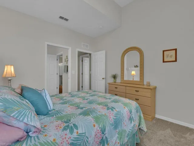 Carpeted bedroom with vaulted ceiling and light gray wall paint
