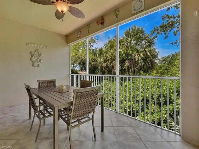 Screened balcony with tile flooring, a ceiling fan with integrated lighting, and a white aluminum railing system