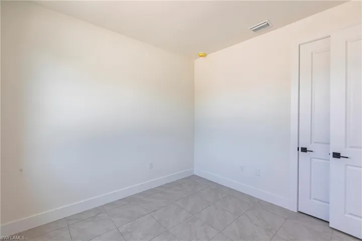 Unfurnished room with visible vents and baseboards