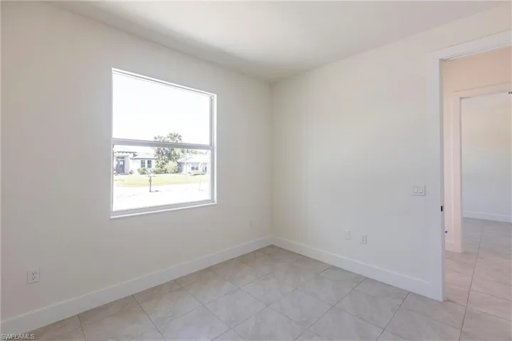 Spare room with baseboards and light tile patterned floors