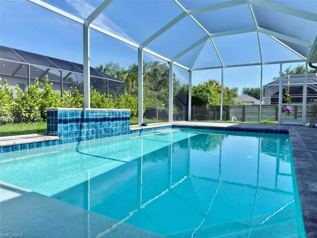 View of swimming pool with glass enclosure, fence, and a fenced in pool