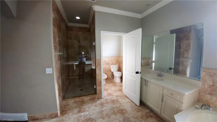 Full bathroom w/dual vanities, large separate shower, bidet & commode and ornamental molding