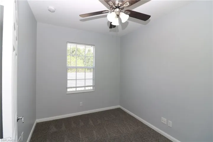 Carpeted empty room featuring ceiling fan