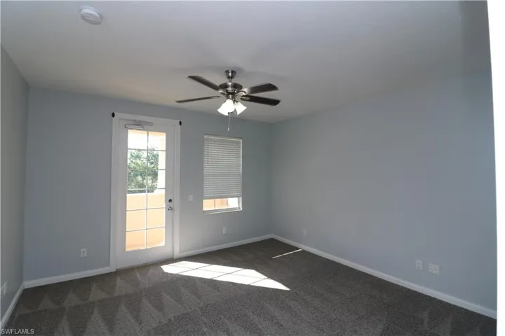 Empty room featuring ceiling fan and carpet floors