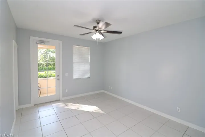 Spare room with ceiling fan and light tile floors