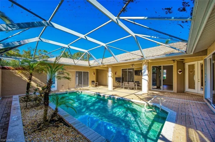 View of pool with ceiling fan, a patio area, and a lanai