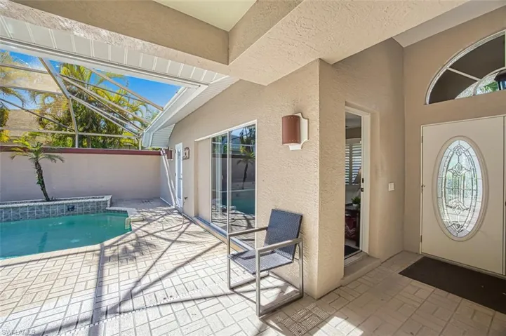View of swimming pool featuring glass enclosure and a patio