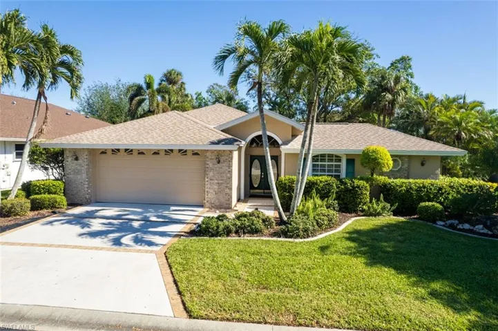 Ranch-style home with a front lawn and a garage